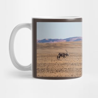 Gemsbok walking on the sandy plain. Mug